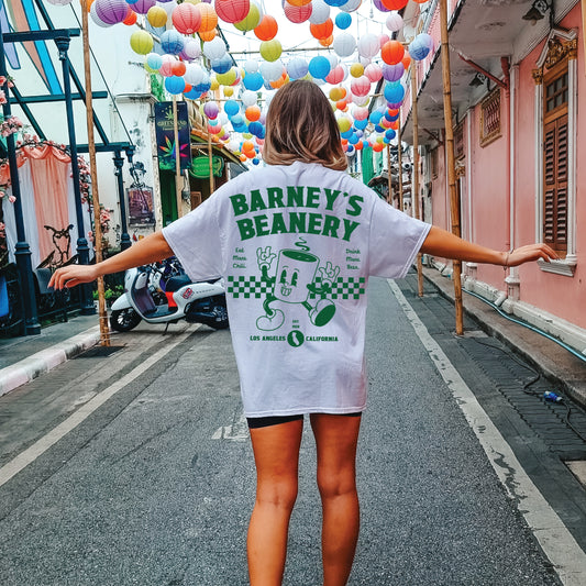 Eat More Chili. Drink More Beer. | BARNEY'S BEANERY - Women's Retro Graphic Tee | White Comfort Colors 1717 T-Shirt - Big Green Graphic On Back View Of Female Lifestyle Image