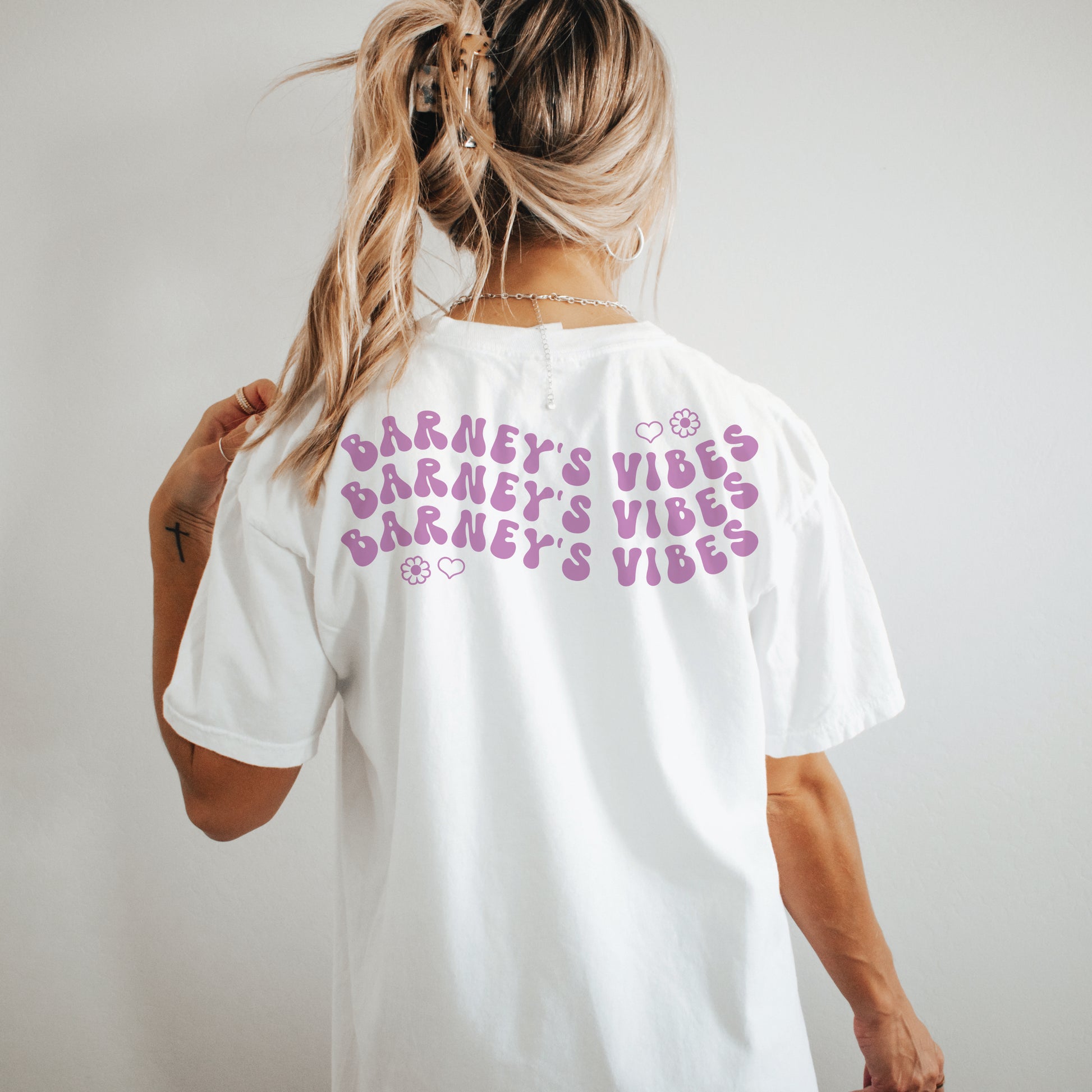 Barney's Vibes | BARNEY'S BEANERY - Women's Smiley Face Tee | Berry Wavy Text Graphic On White T-Shirt, Back View Female Lifestyle Image