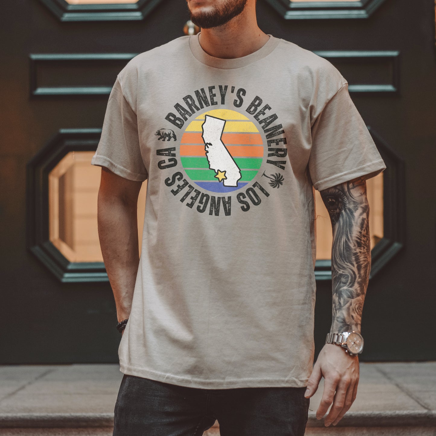 Retro Sunset | BARNEY'S BEANERY - Men's Retro Graphic Tee | Sand Gildan 5000, Front View Male Lifestyle Image